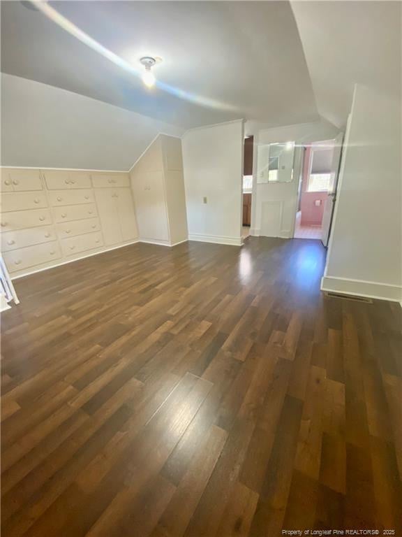 additional living space with lofted ceiling and dark wood-type flooring