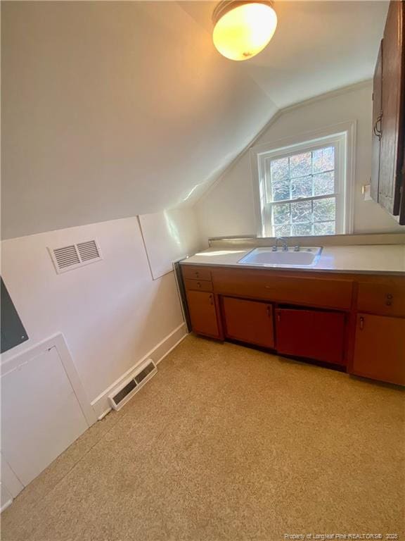 additional living space featuring vaulted ceiling and sink