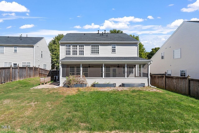 rear view of property featuring ceiling fan, a yard, and a sunroom