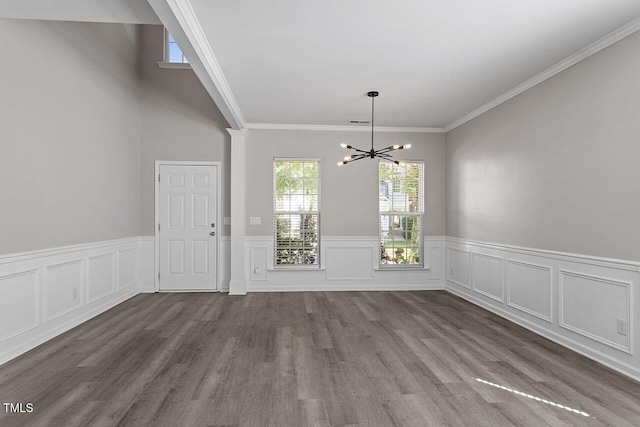 unfurnished dining area featuring hardwood / wood-style flooring, ornamental molding, and a chandelier