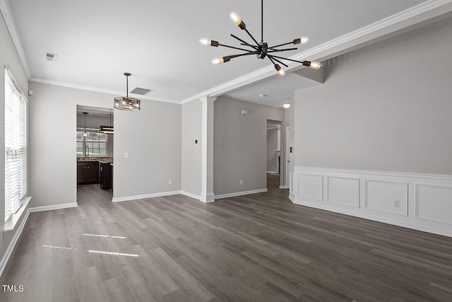 unfurnished living room with dark hardwood / wood-style flooring, crown molding, and a chandelier