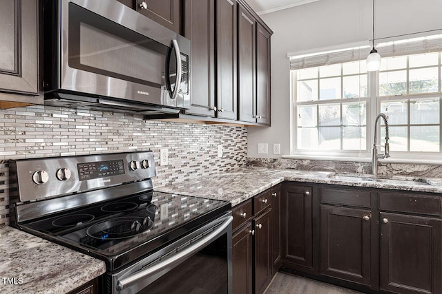 kitchen featuring pendant lighting, stainless steel appliances, sink, and a wealth of natural light