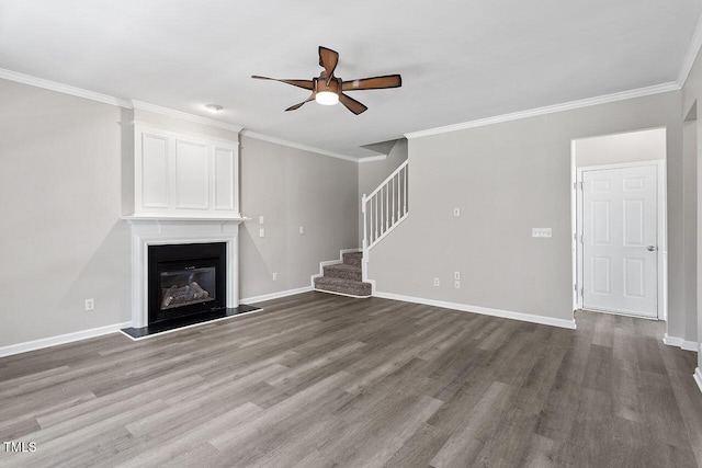 unfurnished living room featuring crown molding, a large fireplace, ceiling fan, and hardwood / wood-style floors