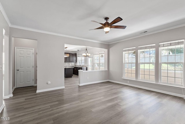 unfurnished living room featuring sink, ceiling fan with notable chandelier, dark wood-type flooring, and ornamental molding