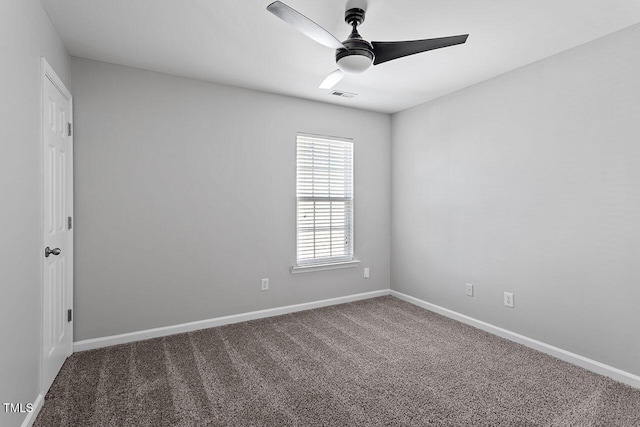 empty room with ceiling fan and dark colored carpet