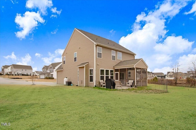 rear view of property with a sunroom and a lawn