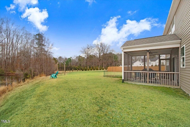 view of yard featuring ceiling fan and a sunroom