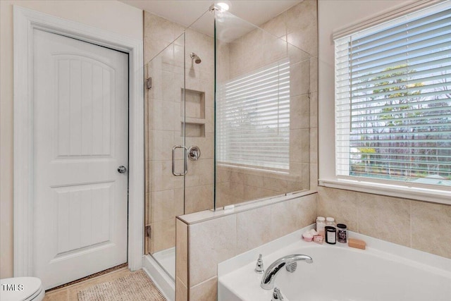 bathroom featuring plus walk in shower and toilet