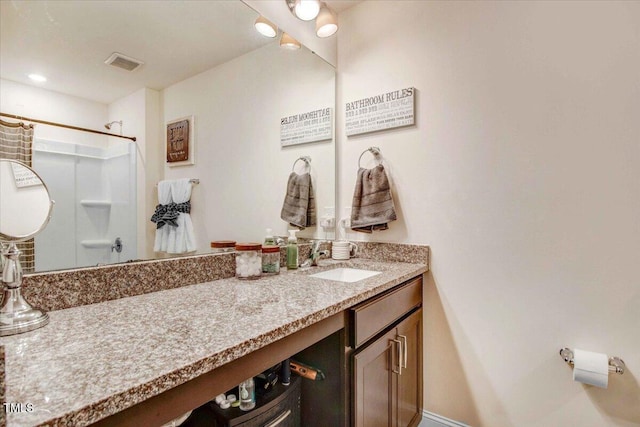 bathroom featuring walk in shower and vanity