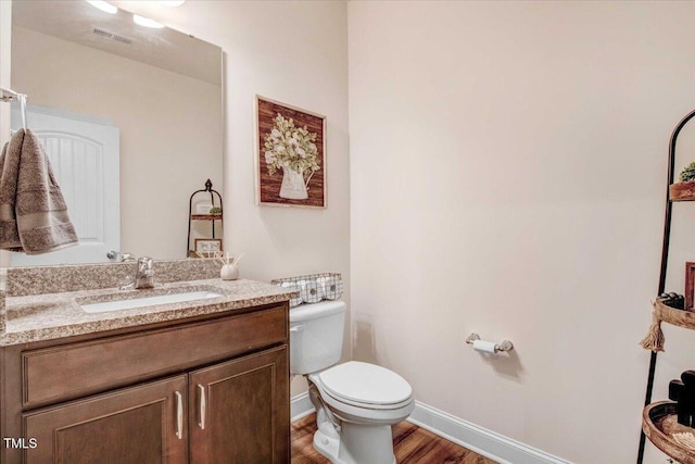 bathroom featuring vanity, wood-type flooring, and toilet