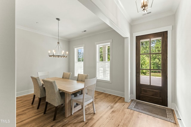 dining space with crown molding, light hardwood / wood-style flooring, and a notable chandelier