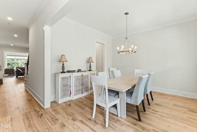 dining room with ornamental molding, light hardwood / wood-style floors, and a chandelier