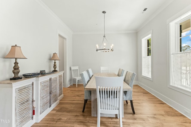 dining space with crown molding, a notable chandelier, and light hardwood / wood-style flooring