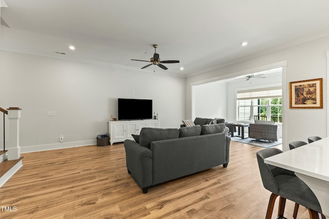 living room featuring light hardwood / wood-style flooring, ornamental molding, and ceiling fan