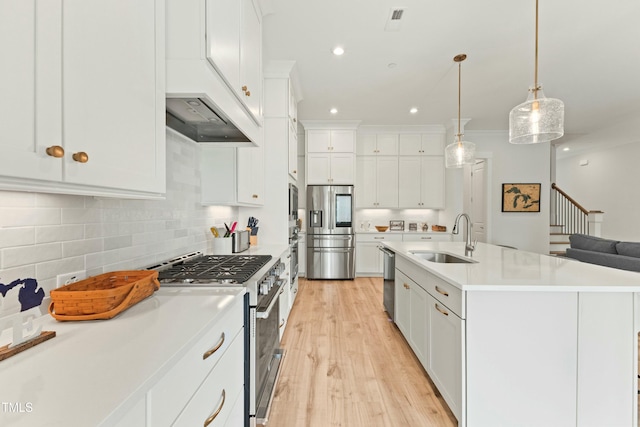 kitchen featuring white cabinetry, stainless steel appliances, decorative light fixtures, and sink