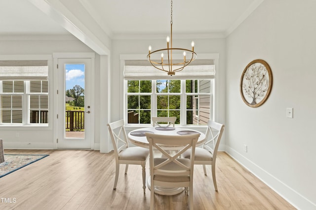 dining space featuring a notable chandelier, light hardwood / wood-style flooring, and ornamental molding