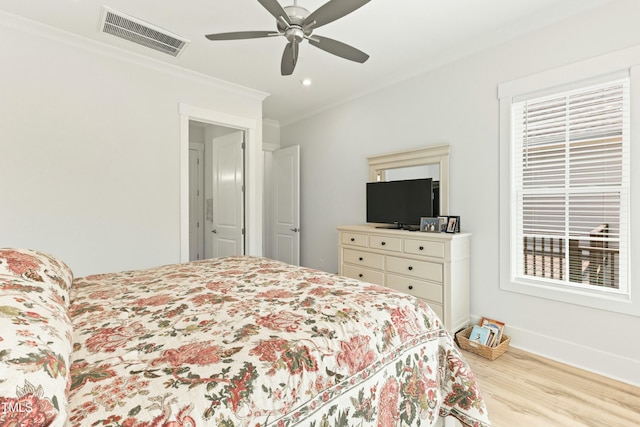 bedroom with crown molding, light hardwood / wood-style flooring, and ceiling fan