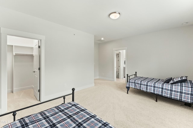 carpeted bedroom featuring a spacious closet and a closet