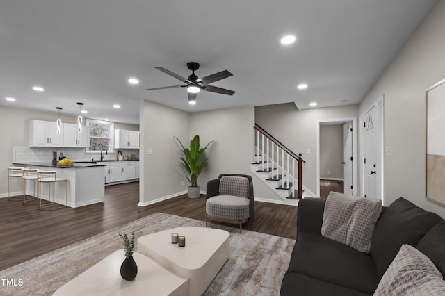 living room featuring ceiling fan, dark hardwood / wood-style flooring, and sink