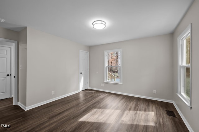 spare room with dark wood-type flooring