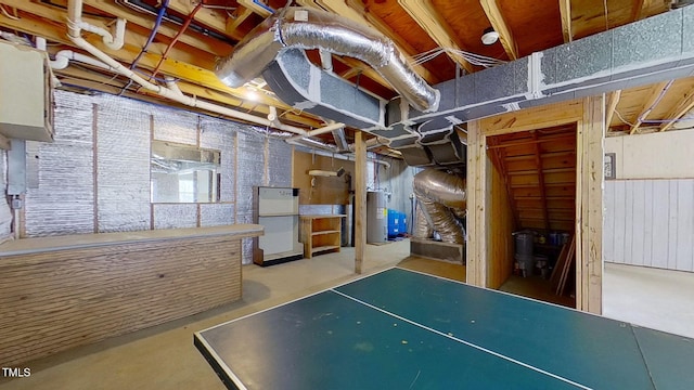 basement featuring electric water heater and refrigerator