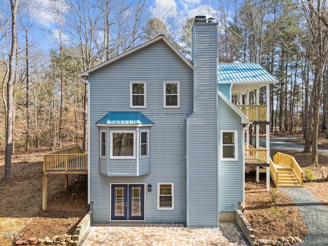 back of house featuring a balcony, a deck, and french doors