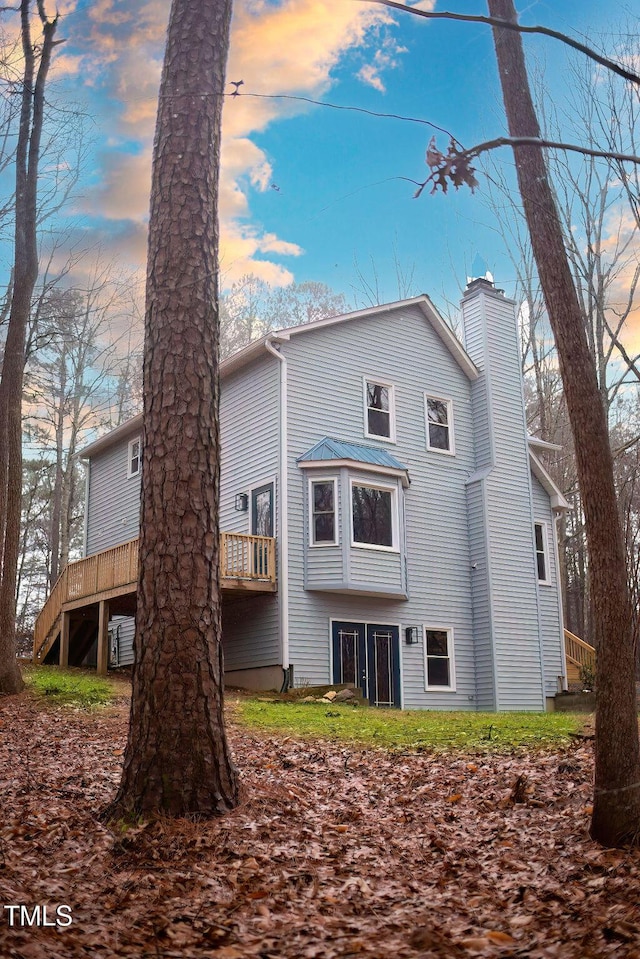 back house at dusk with a deck