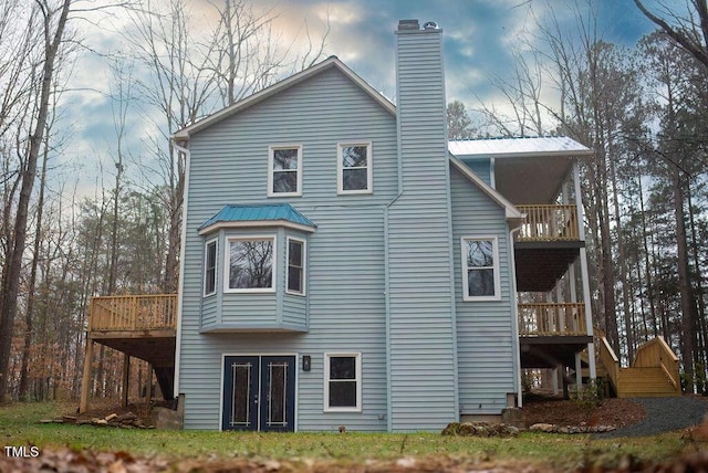 back of property with a balcony and a deck