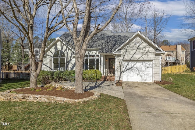 traditional-style home featuring a front lawn, an attached garage, driveway, and fence