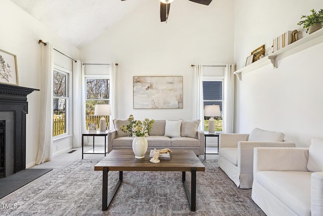 living room featuring visible vents, carpet, a fireplace with flush hearth, high vaulted ceiling, and a ceiling fan