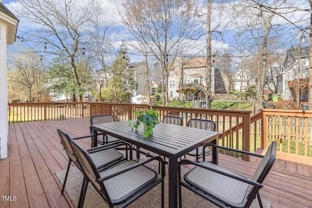 deck with outdoor dining space and a residential view