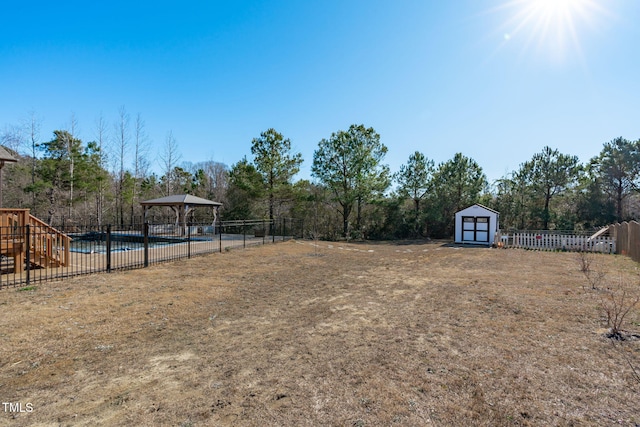 view of yard featuring a shed, a fenced in pool, and a gazebo