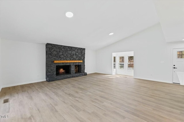 unfurnished living room with lofted ceiling, a fireplace, and light hardwood / wood-style flooring