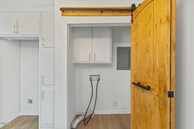 laundry room with cabinets, washer hookup, electric panel, and light hardwood / wood-style flooring