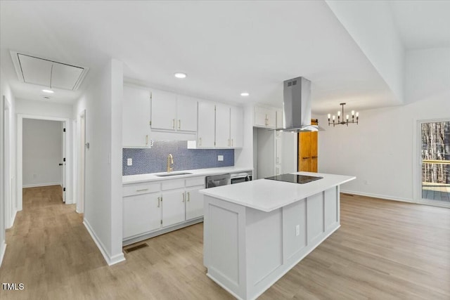 kitchen with decorative light fixtures, white cabinetry, sink, island exhaust hood, and black electric cooktop