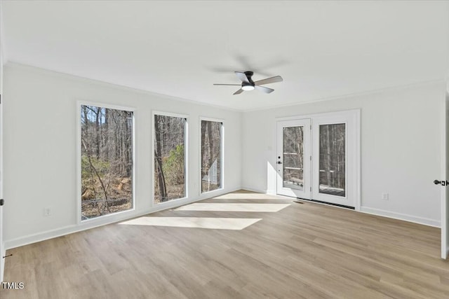 spare room with crown molding, ceiling fan, and light wood-type flooring