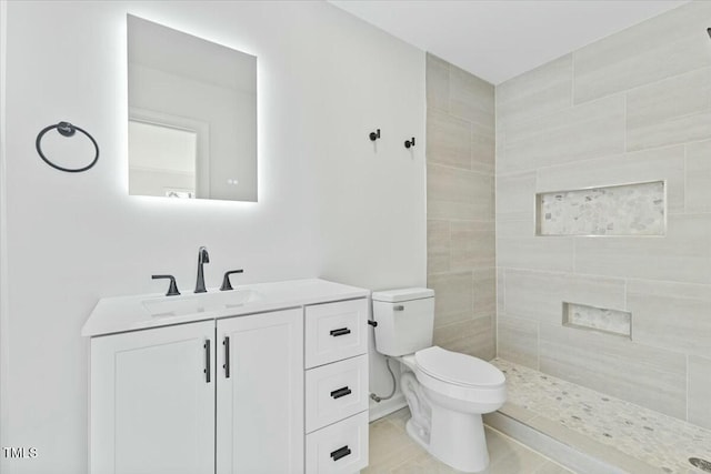 bathroom featuring tiled shower, vanity, and toilet