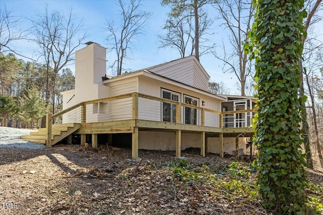 rear view of house with a sunroom and a deck