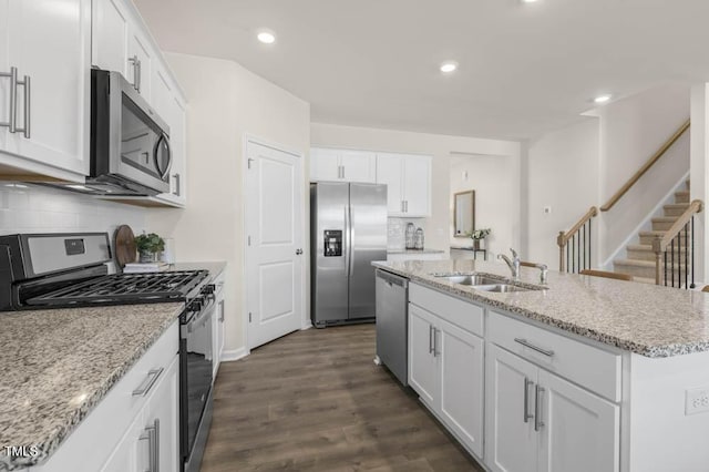 kitchen featuring white cabinetry, stainless steel appliances, sink, and an island with sink