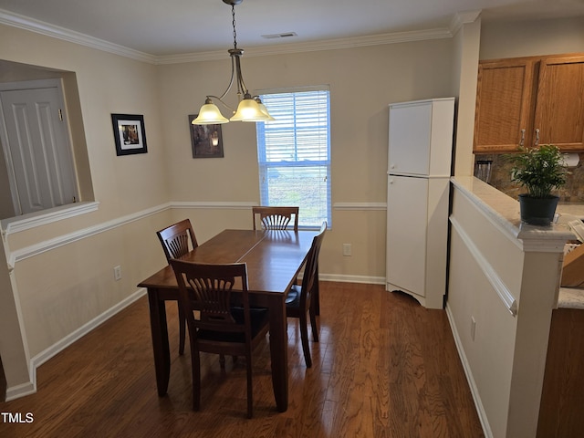 dining space featuring dark wood-type flooring and ornamental molding