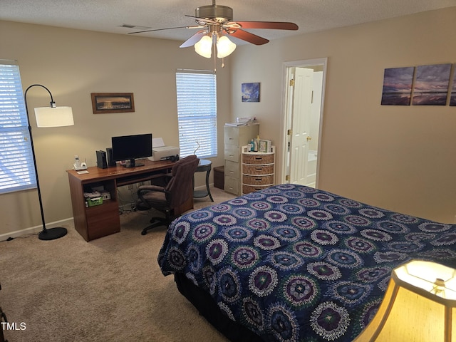 bedroom with light carpet, a textured ceiling, ensuite bath, and ceiling fan