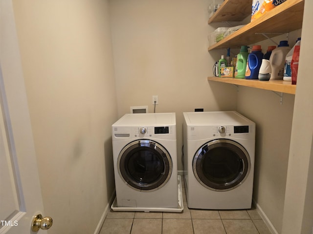 laundry area with light tile patterned floors and washing machine and clothes dryer