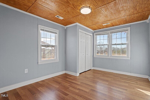 unfurnished bedroom featuring hardwood / wood-style floors, multiple windows, and wooden ceiling