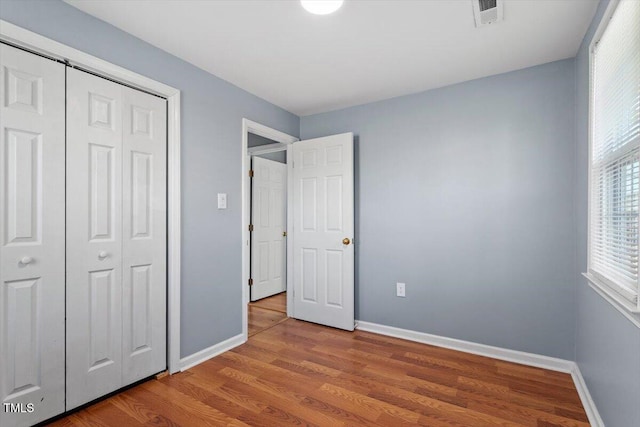 unfurnished bedroom with light hardwood / wood-style floors and a closet