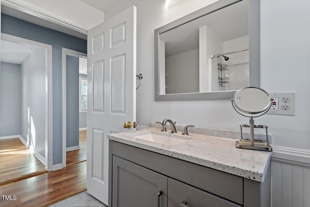 bathroom featuring hardwood / wood-style flooring, a shower, and vanity