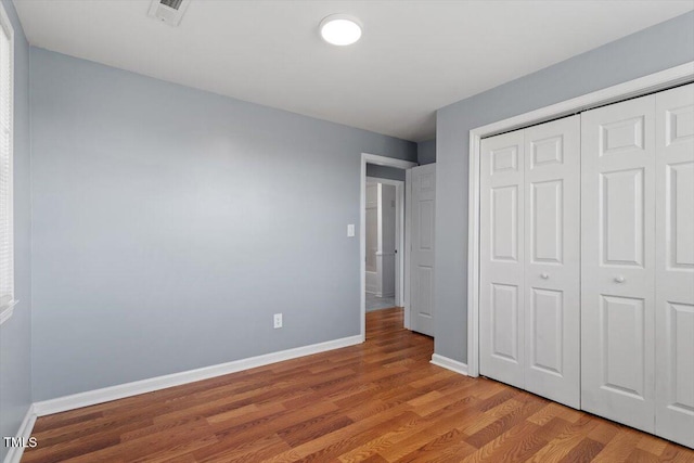 unfurnished bedroom with a closet and light hardwood / wood-style flooring