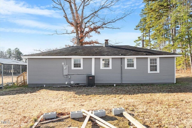 rear view of property with cooling unit and a lawn