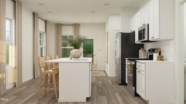 kitchen featuring tasteful backsplash, appliances with stainless steel finishes, a kitchen island with sink, and white cabinets