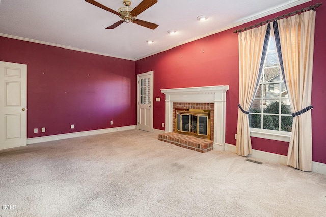 unfurnished living room featuring crown molding, a fireplace, carpet flooring, and ceiling fan