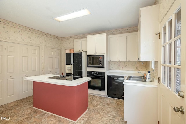 kitchen with a center island, sink, white cabinets, and black appliances